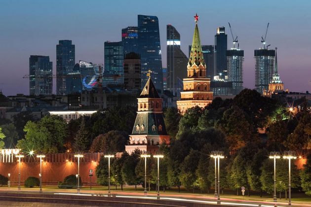 Вид на стену и башни Московского Кремля на фоне делового центра «Москва-Сити» на закате